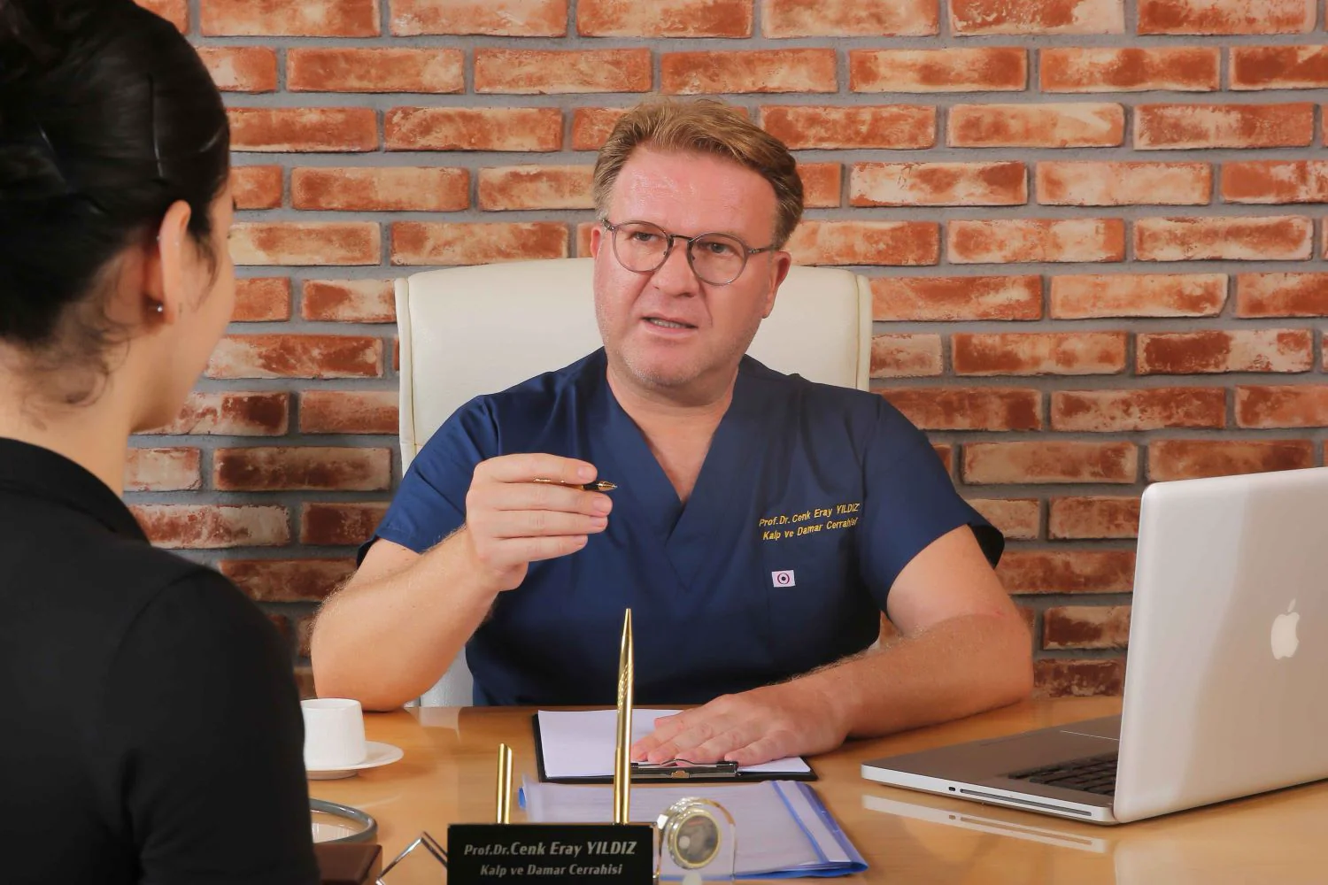 Prof. Dr. Cenk Eray Yıldız consulting a patient